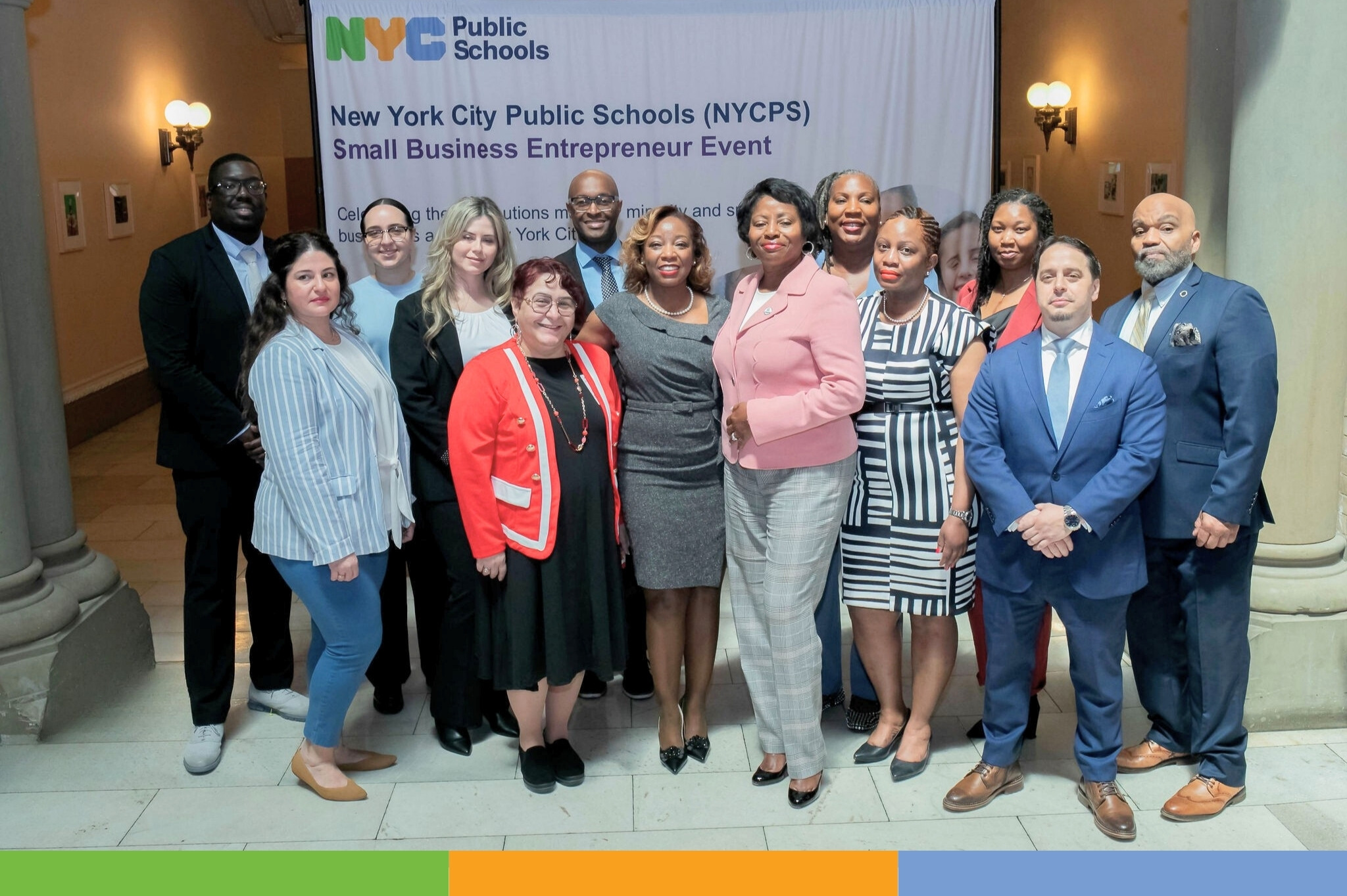 a group of people in front of an mwbe logo a group of people in front of an mwbe logo