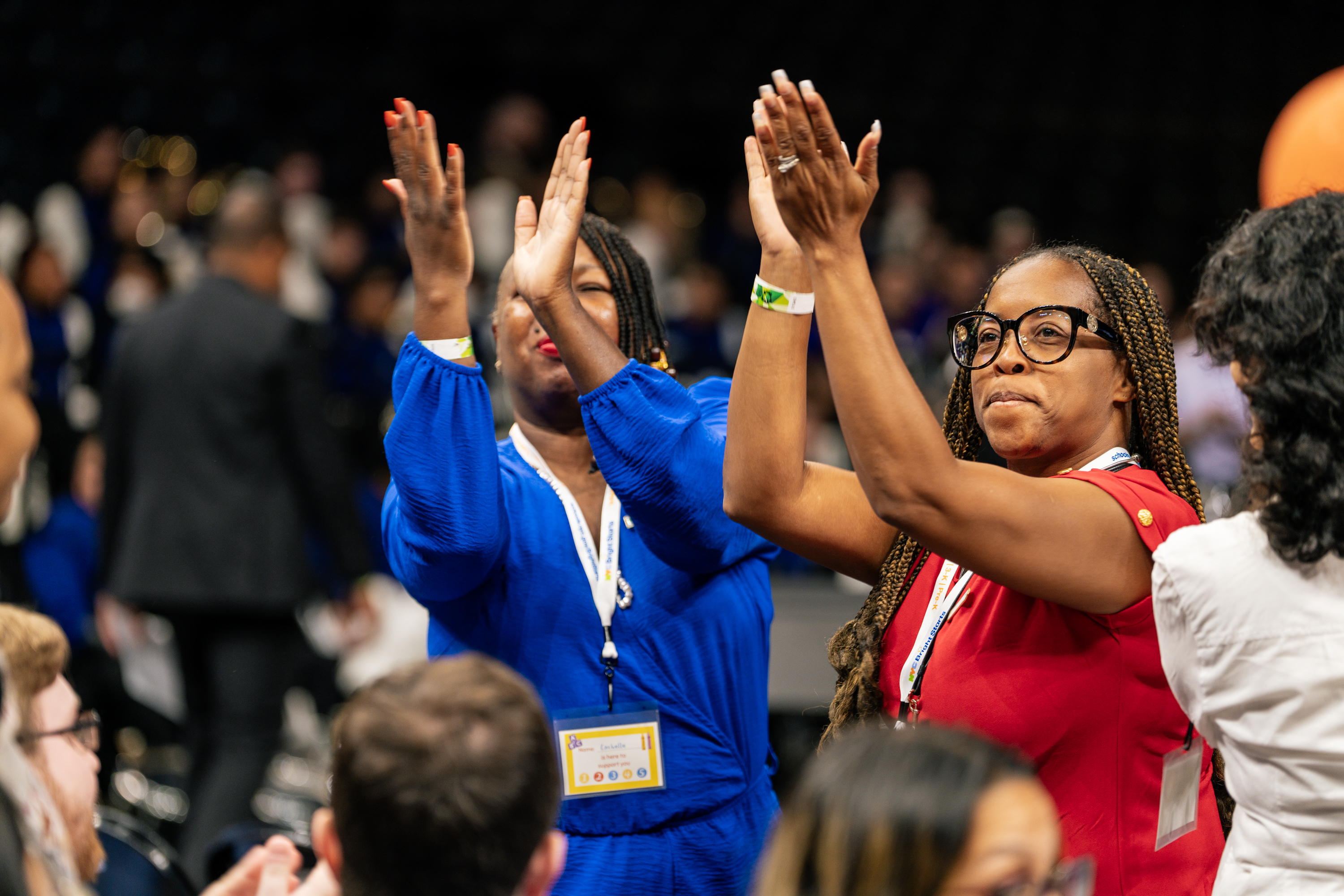 Two women in dresses clapping, cheering